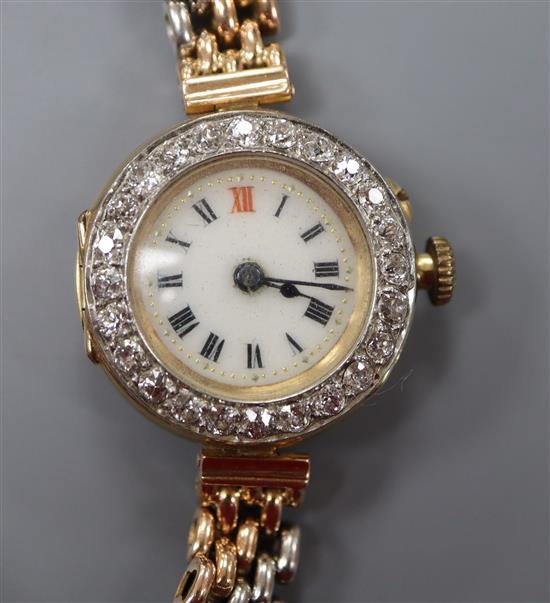 A ladys Edwardian 18ct gold manual wind wrist watch with diamond set bezel, on a two colour yellow metal bracelet.